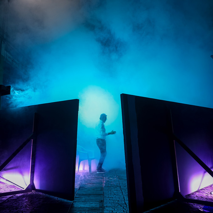 Industriegebäude, das durch Raumtrenner getrennt ist. In der Mitte steht eine Person in blauem Licht