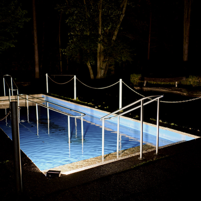 Blau beleuchteter Swimming Pool in der Nacht