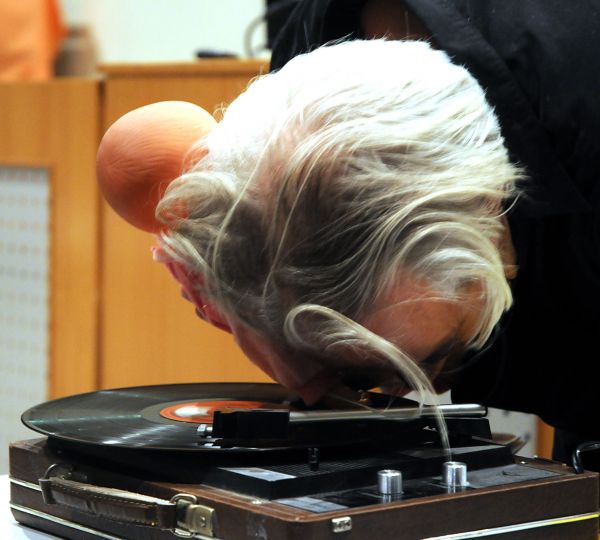 Licht Aus grauhaariger Mann liegt mit seiner Stirn auf einem Plattenspieler mit einer Schallplatte