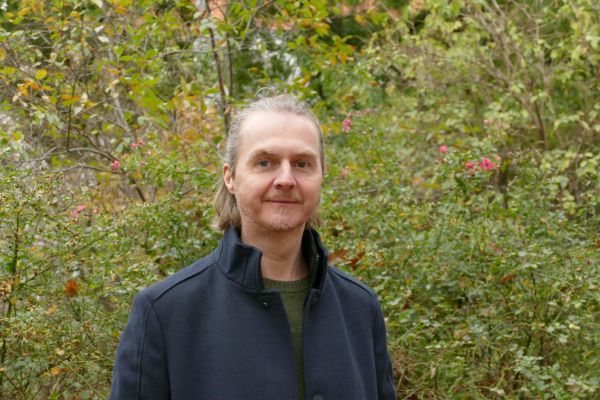 Kunst und Antisemitismus Mann steht vor einem Naturhintergrund und schaut in die Kamera