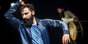 Mann tanzt, im Hintergrund ein Mann mit Trommel